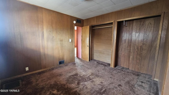 807 S 11th Ave, Yakima, WA 98908 - unfurnished bedroom with wooden walls, two closets, and carpet flooring