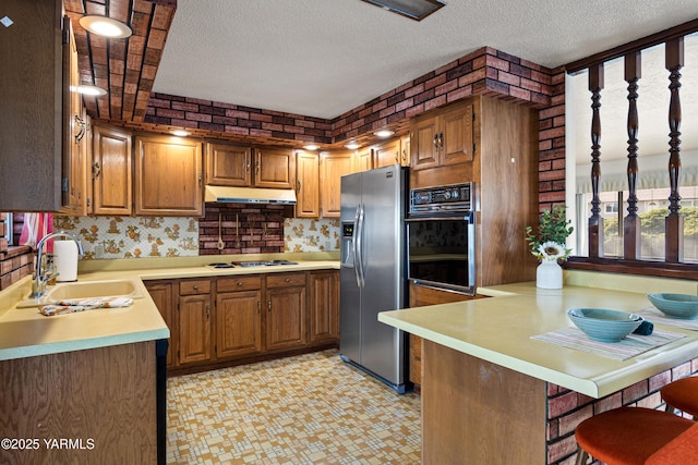 kitchen with stainless steel refrigerator with ice dispenser, light countertops, white gas cooktop, oven, and a peninsula