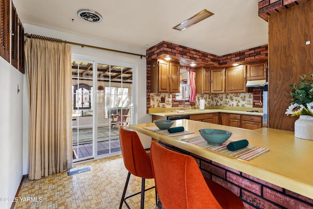 kitchen featuring light countertops, a sink, visible vents, and dishwasher