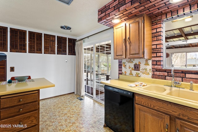 kitchen with plenty of natural light, light countertops, dishwasher, and a sink