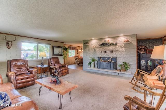 carpeted living area with ornamental molding, a fireplace, and a textured ceiling