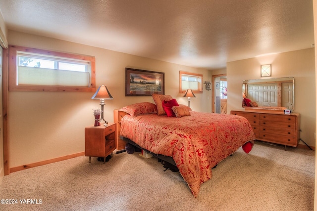 carpeted bedroom with a textured ceiling and baseboards