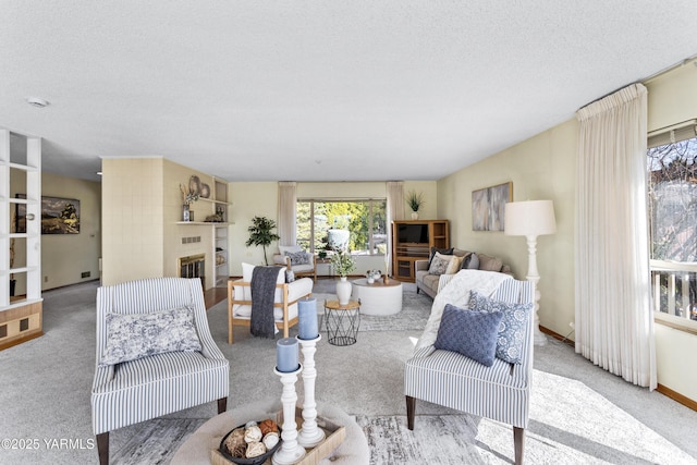 carpeted living area featuring a glass covered fireplace and a textured ceiling