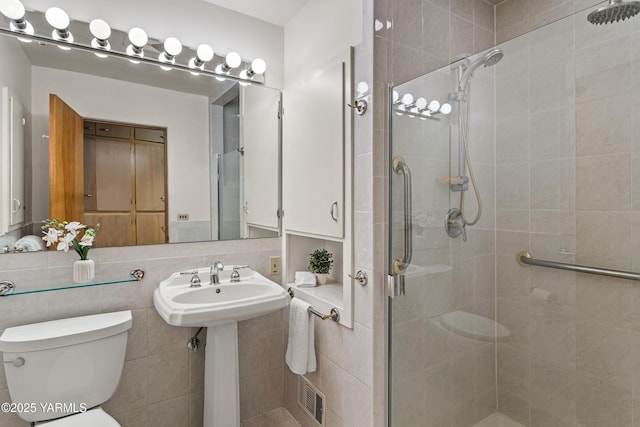 bathroom featuring visible vents, backsplash, a shower stall, toilet, and a sink