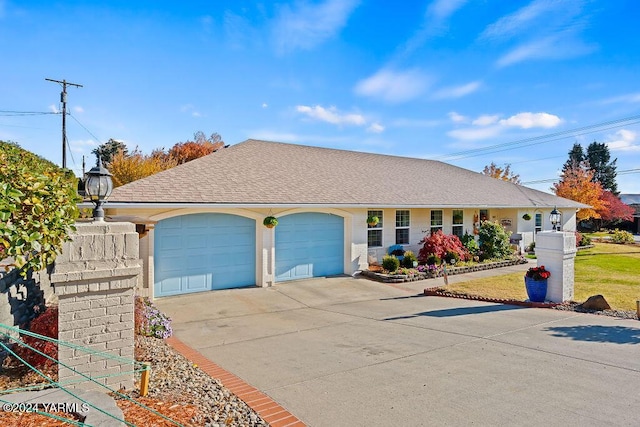 ranch-style house with a garage, concrete driveway, and roof with shingles