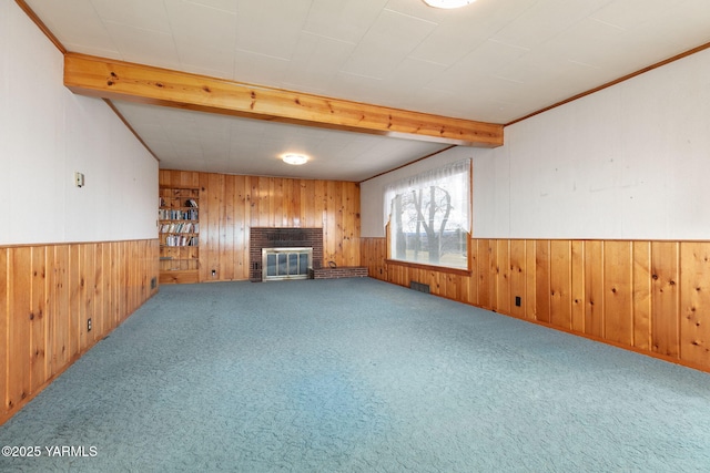 unfurnished living room featuring a brick fireplace, carpet, a wainscoted wall, and wood walls