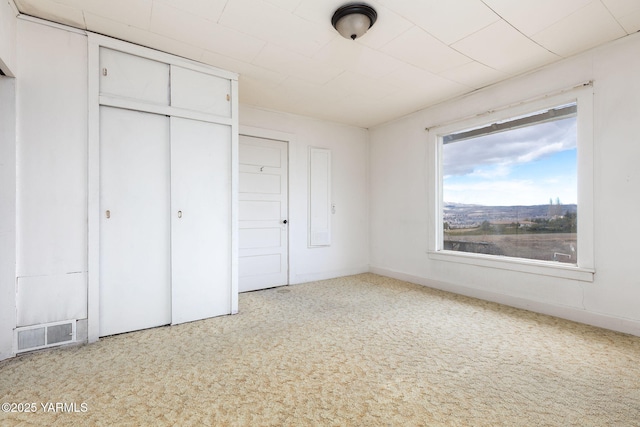 unfurnished bedroom with a closet, visible vents, and carpet flooring