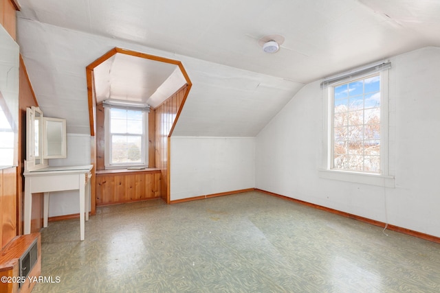 bonus room with vaulted ceiling, light floors, and baseboards