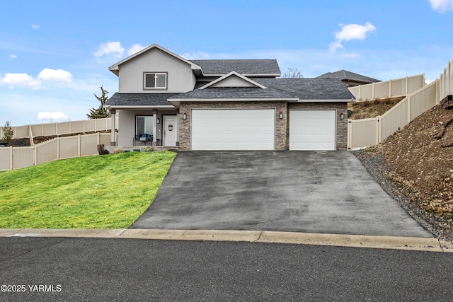 traditional-style house with an attached garage, a shingled roof, fence, stucco siding, and a front yard