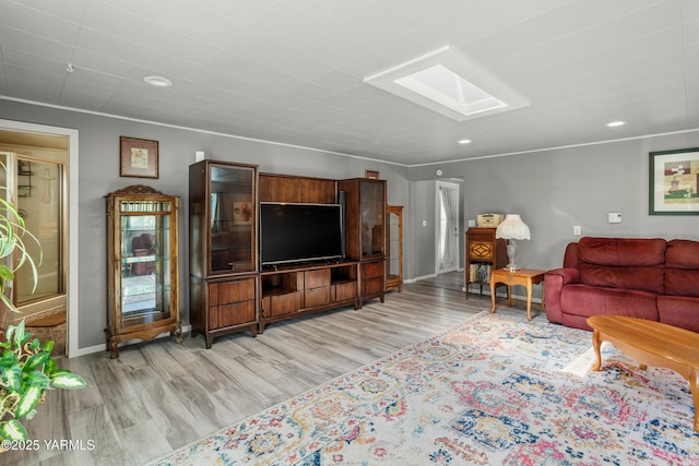 living area with recessed lighting, a skylight, baseboards, and light wood finished floors