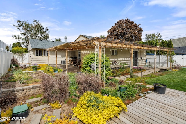 rear view of property featuring a pergola, a shingled roof, a wooden deck, and a fenced backyard