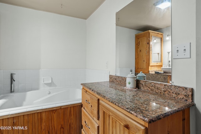 bathroom with a garden tub and vanity
