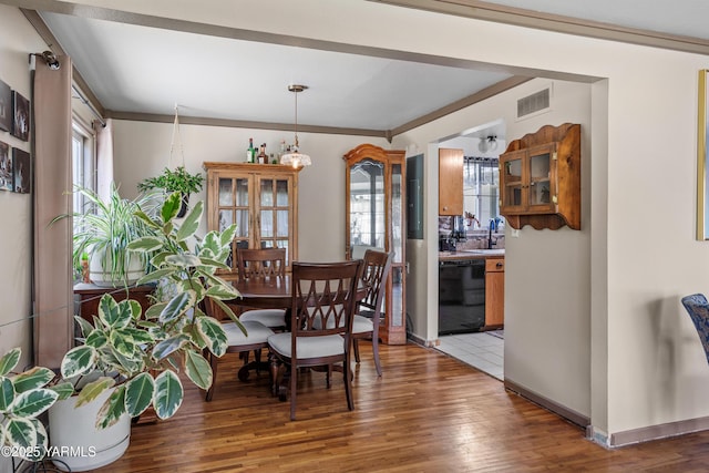 dining room with baseboards, visible vents, and light wood finished floors