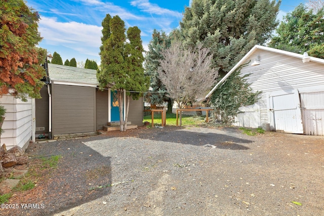 single story home featuring entry steps, an outdoor structure, and fence