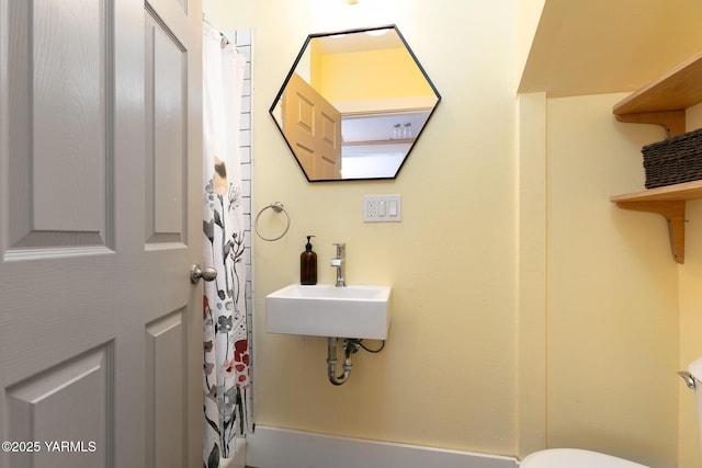 full bathroom with curtained shower, a sink, and toilet