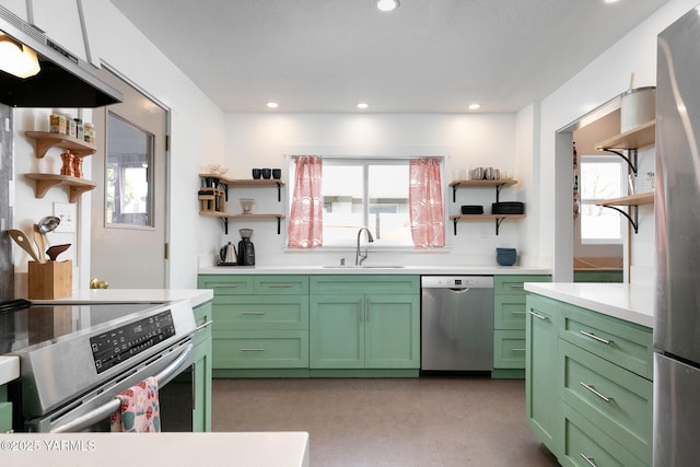 kitchen with stainless steel appliances, green cabinets, a sink, and open shelves