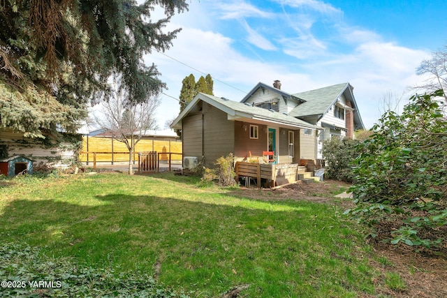 rear view of property with a yard, fence, and a chimney