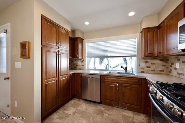215 N 56th Ave Unit 42, Yakima, WA 98908 - kitchen with stainless steel appliances, backsplash, light countertops, brown cabinetry, and recessed lighting