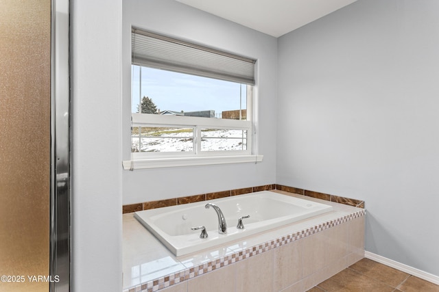 full bath with tile patterned flooring, a garden tub, and baseboards