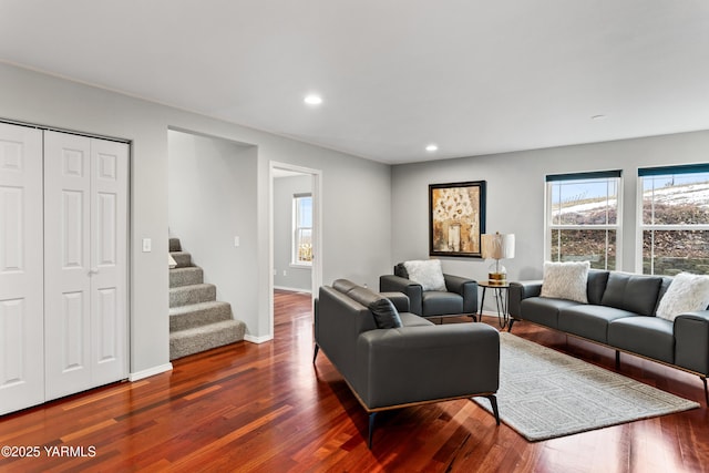 living room featuring stairs, baseboards, dark wood finished floors, and recessed lighting