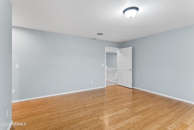 spare room with baseboards, visible vents, and light wood-style floors