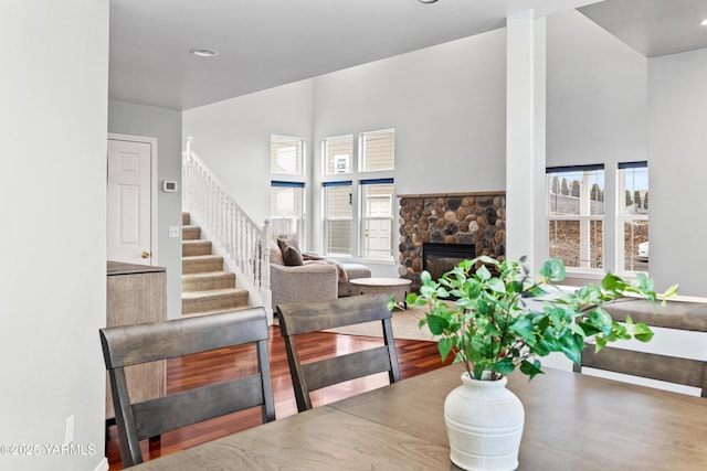 dining room with stairs, a fireplace, and wood finished floors