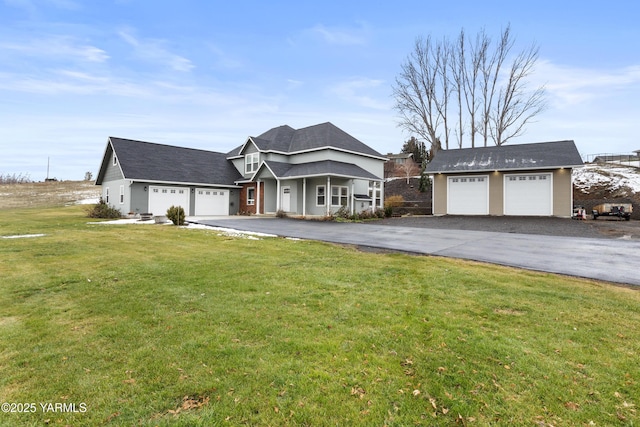 view of front of home with a garage, aphalt driveway, and a front yard