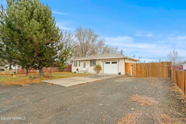 ranch-style home with driveway, a garage, and fence