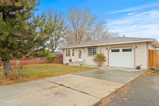 single story home featuring a front lawn, driveway, an attached garage, and fence