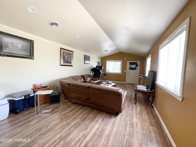 living room with lofted ceiling, light wood finished floors, visible vents, and baseboards