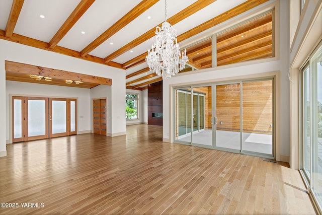 8 N 96th Ave, Yakima, WA 98908 - spare room featuring a chandelier, french doors, beam ceiling, light wood-style floors, and a large fireplace