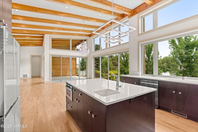 8 N 96th Ave, Yakima, WA 98908 - kitchen with stainless steel appliances, beam ceiling, light countertops, dark brown cabinetry, and a chandelier