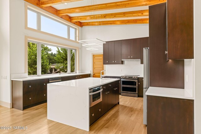 8 N 96th Ave, Yakima, WA 98908 - kitchen featuring stainless steel electric stove, a towering ceiling, light wood-style floors, light countertops, and beam ceiling