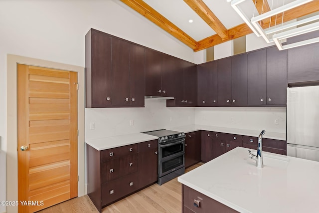 8 N 96th Ave, Yakima, WA 98908 - kitchen with stainless steel appliances, light countertops, light wood-style floors, dark brown cabinetry, and beam ceiling