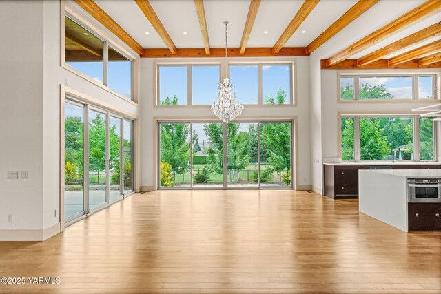 8 N 96th Ave, Yakima, WA 98908 - unfurnished living room featuring beamed ceiling, a chandelier, hardwood / wood-style floors, and a towering ceiling
