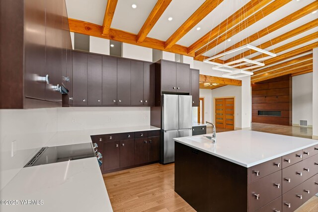 8 N 96th Ave, Yakima, WA 98908 - kitchen featuring freestanding refrigerator, light wood-style flooring, range with electric stovetop, light countertops, and an island with sink