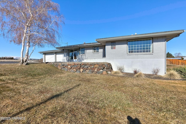 back of property with brick siding and a lawn