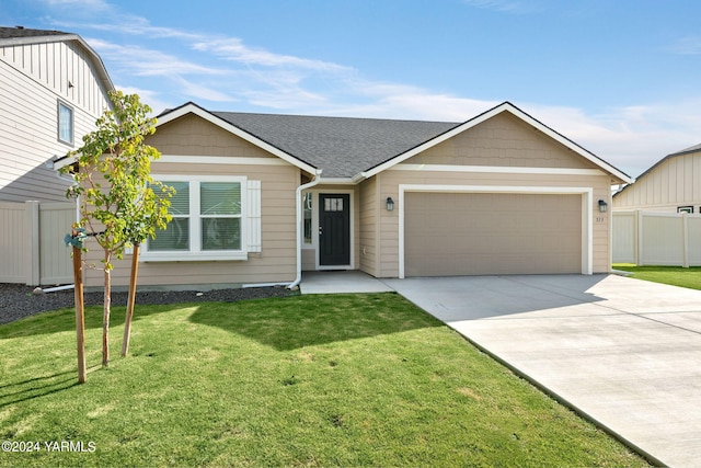 ranch-style home featuring a garage, a front lawn, and fence