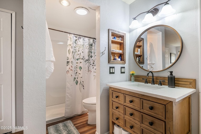 bathroom featuring vanity, a shower with curtain, toilet, and wood finished floors
