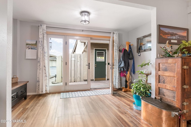 doorway with light wood-style floors and baseboards