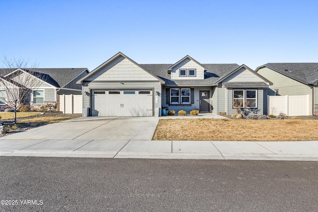 craftsman house featuring a garage, driveway, and fence