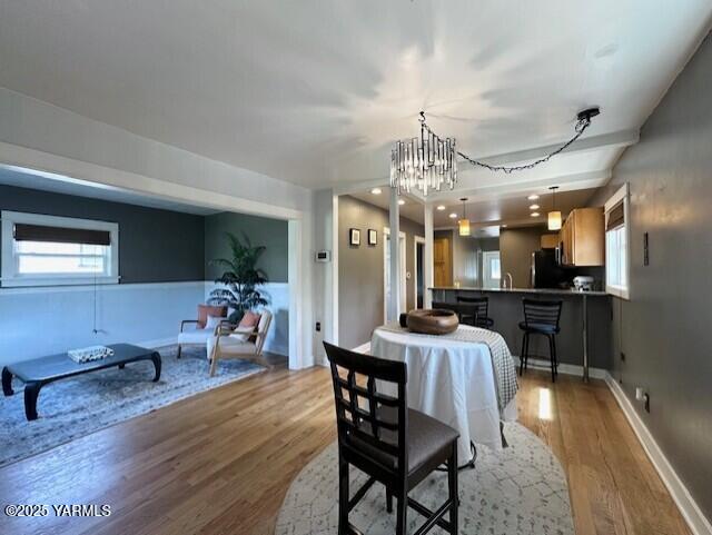 1115 S 20th Ave `, Unit Yakima, WA 98902 - dining space with wood finished floors, healthy amount of natural light, a chandelier, and baseboards