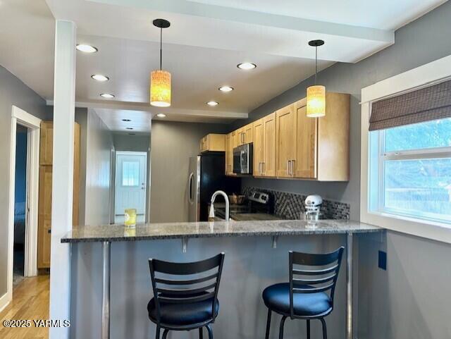 1115 S 20th Ave `, Unit Yakima, WA 98902 - kitchen featuring appliances with stainless steel finishes, a peninsula, plenty of natural light, light stone countertops, and recessed lighting