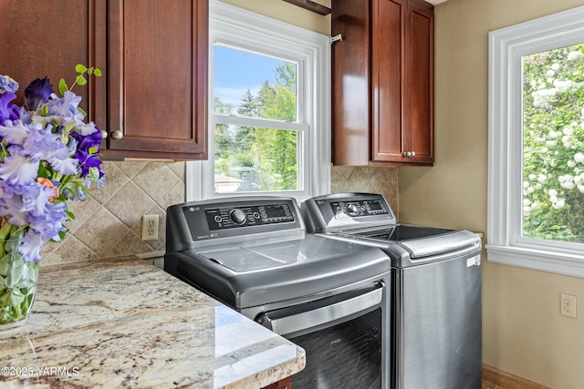 laundry room with washer and dryer, cabinet space, and healthy amount of natural light