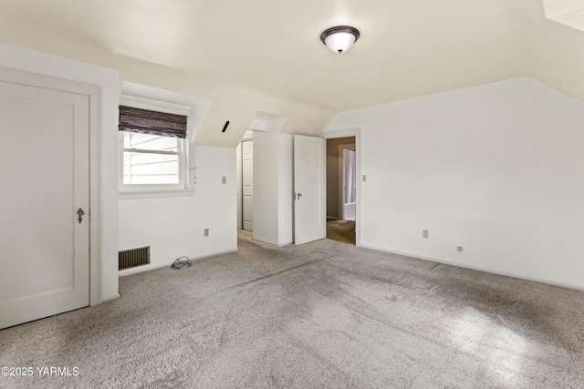 unfurnished bedroom featuring lofted ceiling and carpet floors
