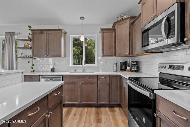 19700 N Beers Rd, Prosser, WA 99350 - kitchen featuring appliances with stainless steel finishes, open shelves, light countertops, light wood-type flooring, and tasteful backsplash