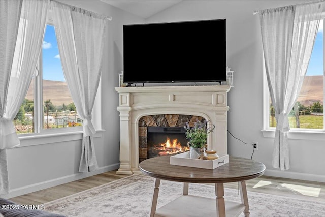 19700 N Beers Rd, Prosser, WA 99350 - living area featuring light wood finished floors, a warm lit fireplace, plenty of natural light, and lofted ceiling
