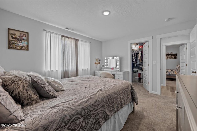 19700 N Beers Rd, Prosser, WA 99350 - bedroom with light colored carpet, a walk in closet, a closet, and a textured ceiling