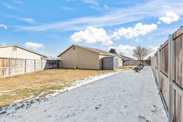 exterior space with a fenced backyard, a storage unit, and an outbuilding