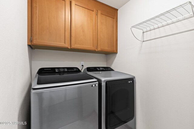 laundry area with washing machine and dryer and cabinet space